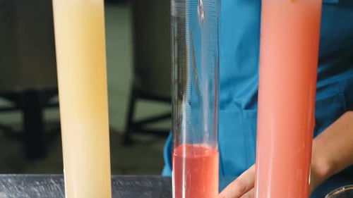 Un scientifique verse du liquide vinicole dans un tube à essai pour contrôler la qualité