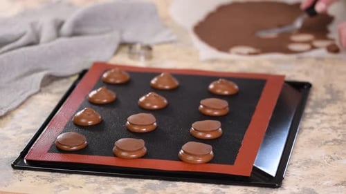 Assembling Chocolate Macaroons on Baking Sheet at Home