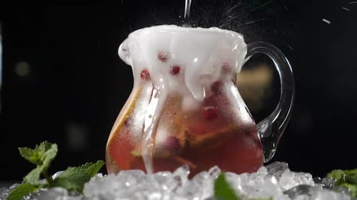 Refreshing Drink Poured into Glass Pitcher with Ice