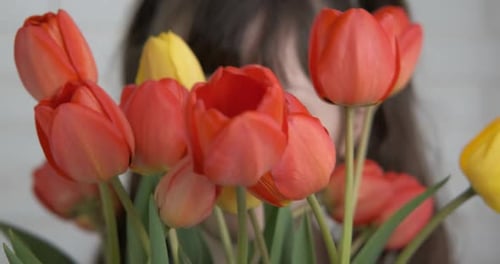 Smiling Child with Red and Yellow Tulips