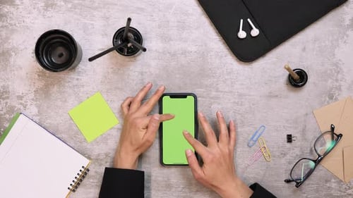 Female tapping on smartphone device with green screen