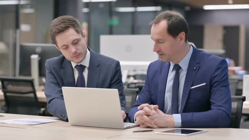 Businessmen Work Together on Laptop in Modern Office