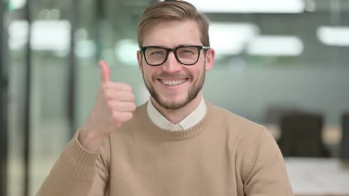 Smiling Man Gives Thumbs Up in the Office