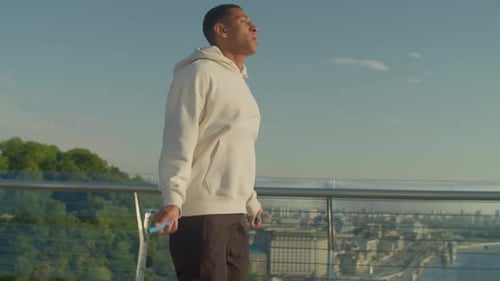 Athletic Man Exercising With Jump Rope Outdoors