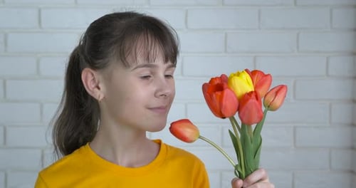 Girl Smelling Red and Yellow Tulips