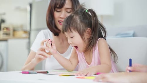 Woman Drawing with Child at Table Inside Home