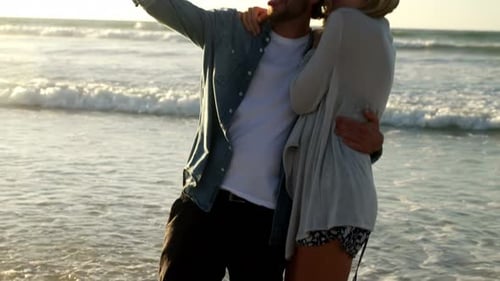 Couple taking selfie on mobile phone at beach