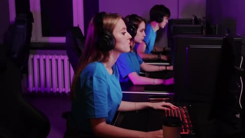 Online Gaming Three Friends Sitting in the Gaming Club and Having an Online Tournament Losing the
