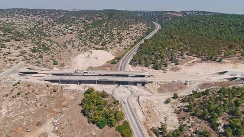 Aerial footage of large highway construction project with tunnels and bridges