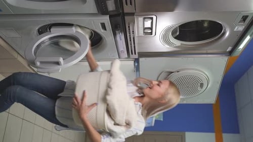 Smiling Woman Doing Laundry in Laundromat