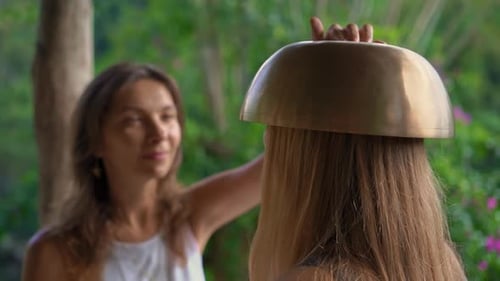 Woman Places Singing Bowl on Head Outdoors