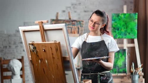 Happy Hipster Creative Female Painter Enjoying Drawing Picture on Canvas at Art Studio Medium Shot