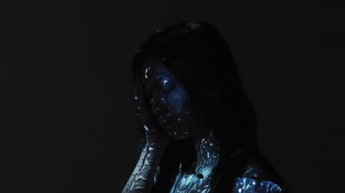 Woman in Dark with Abstract Lighting Posing Artistically