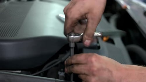 Un mécanicien dévisse les détails du moteur de la voiture