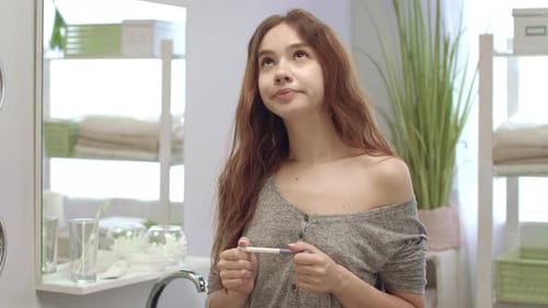 Young Woman Reacts to Positive Pregnancy Test