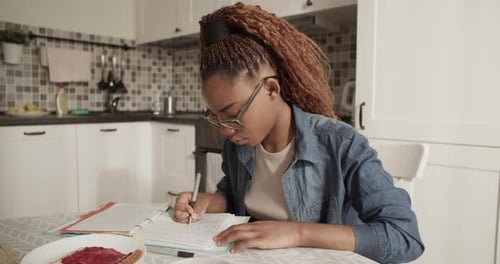 Woman Studying at Kitchen Table