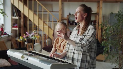 Une femme montre à la jeune fille les bases du chant et utilise le piano