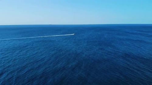 Sports Police Boat or Coast Guard Boat Is Speeding Across the Sea or Ocean. Aerial Footage From Afar