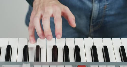 Hand Playing Keyboard Keys in Close Up