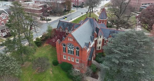 Red brick gothic mansion building with slate roof. Ornate architecture. Aerial establishing shot.