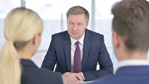 Rear View of Serious Businessman Discussing with Team in Office
