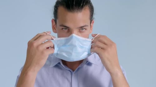 Man Shows How To Correctly Put On Face Mask For Coronavirus Protection - medium close up