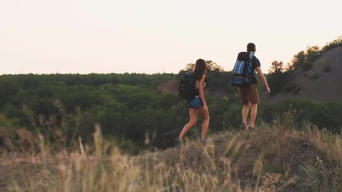 Couple Hiking in Rural Landscape at Sunrise or Sunset