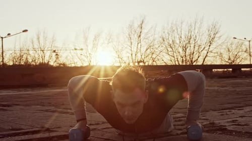 Man Doing Pushups with Weights on Rooftop