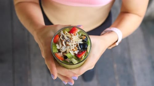 Fitness Female Athlete Holding Green Vegan Detox Smoothie Wearing Activewear