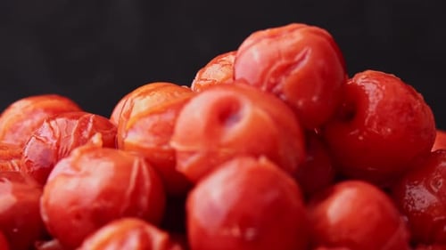 Cerises en conserve tournant sur fond noir Dessert aux cerises ivres Compote filée aux cerises en conserve