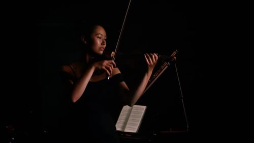 Violinist Playing in a Dark Room