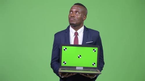 Man in Suit Holds Laptop with Chroma Key