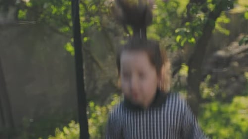 Girl Bouncing on a Trampoline in the Backyard