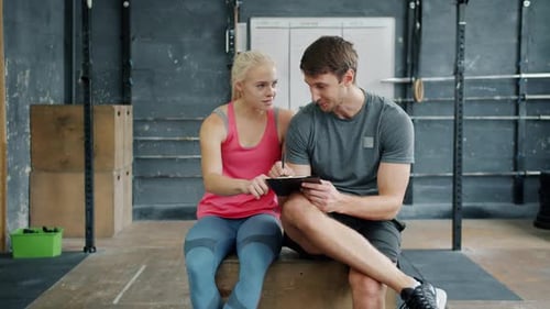 Woman and Man Discuss Fitness Plan at Gym
