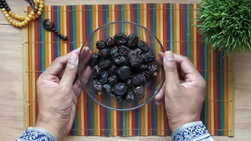 the Concept of Ramadan Hand Pick Date Fruit From a Bowl