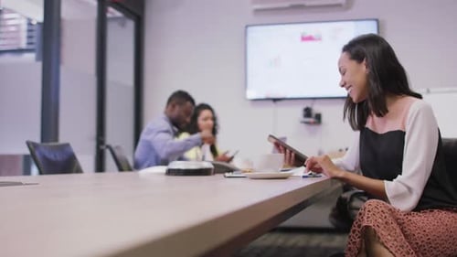 Happy diverse group of business people working together, using tablet in modern office