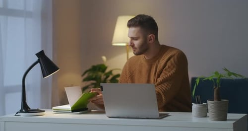 Man Works at Laptop in Home Office
