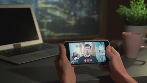 Female Hands Holding Smartphone with Video Calling to the Business Partner