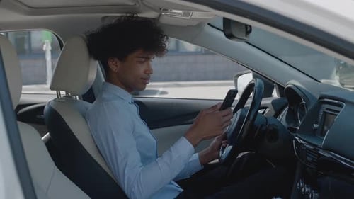 Young Adult Sitting in Car Smiling