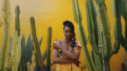 Stylish Woman Posing by Cacti with Yellow Wall