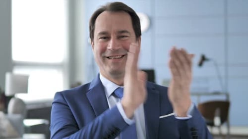 Man in Suit Smiling and Clapping Hands