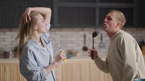 Couple Singing Together in Their Home Kitchen