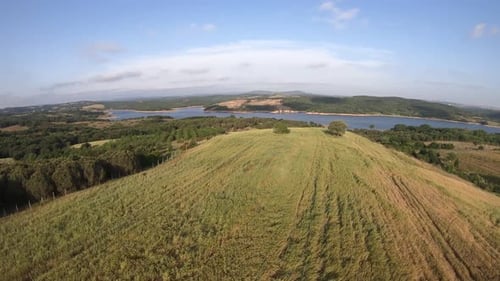 Aerial View of Green Hilltop with Lake