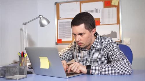 Caucasian Man Working Hard in the Office with Laptop.