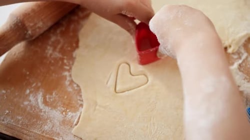Child Cuts Heart Shapes in Dough