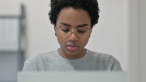 African Woman with Laptop Smiling at Camera