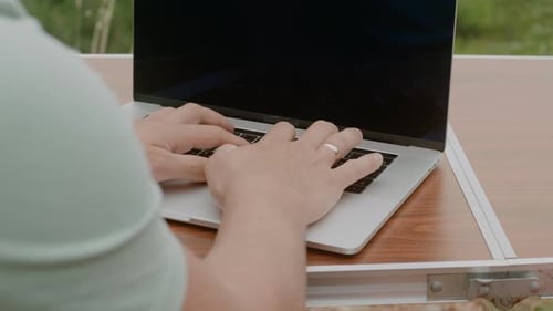 Gros plan des mains masculines tapant sur le clavier de l'ordinateur portable. Travailler sur ordinateur à l'extérieur, Ralentir.