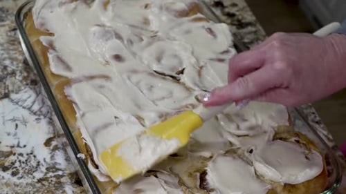 Frischkäseglasur auf frisch gebackenen Zimtschne