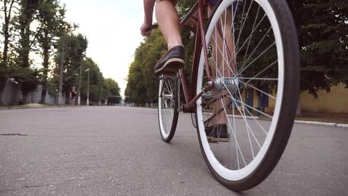 Young Man Riding a Vintage Bicycle at the Park Road. Sporty Guy Cycling Outdoor. Healthy Active