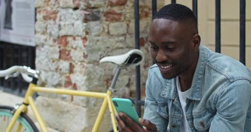 Close Up of Cheerful African American Guy Having a Video Call Via His Smartphone, Smiling While